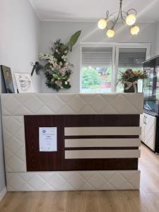 a counter in a kitchen with flowers and a window at Kaleh Boutique Villa in Orşova