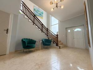 a living room with two chairs and a staircase at Kaleh Boutique Villa in Orşova