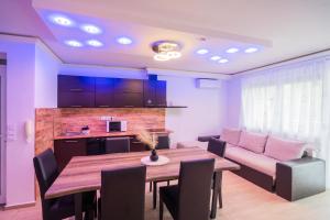 a kitchen and dining room with a table and a couch at AH-Corso Wellness Apartment in Siófok