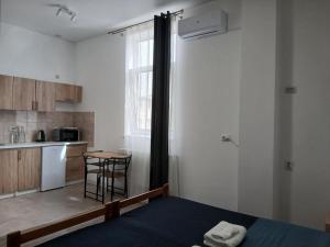 a bedroom with a bed and a kitchen with a table at Апарт-готель Олімпік in Lviv +48 photos