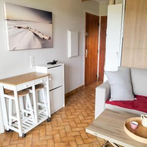 a living room with a couch and a table at Studio cosy avec terrasse et barbecue à Cazaubon - 28 m² in Cazaubon +5 photos