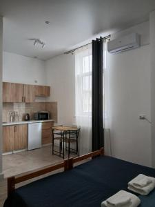 a room with a bed and a kitchen with a table at Апарт-готель Олімпік in Lviv