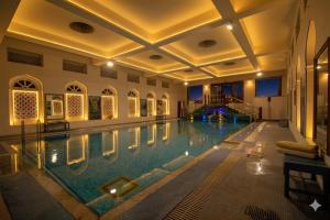 a large swimming pool in a hotel with a ceiling at Hari Mahal Palace by Pachar Group in Jaipur