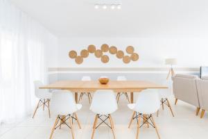 a dining room with a wooden table and white chairs at Laguna - Vilamoura in Vilamoura