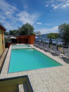 a swimming pool with chairs and a view of the water at Apartments U Zelmanu in Pasohlávky