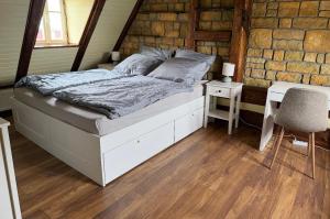 a bedroom with a bed and a table and a chair at House Pankraz Jitrava in Rynoltice
