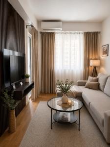 a living room with a couch and a table at Modern New Apartment Miss T I Free Parking I Great Location in Podgorica