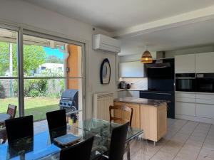 a kitchen and dining room with a glass table at Villa Casa Brisa, pour 6 voyageurs, proche des plages à 8 minutes en vélo in Capbreton