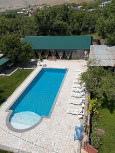 a swimming pool with chaise lounge chairs next to a building at Yvette B&B in Garni