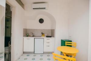 a kitchen with a yellow table and a sink at Casetta Puntino in Atrani +1 photo