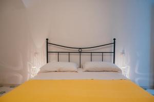 a bed with a yellow blanket and two pillows at Casetta Puntino in Atrani