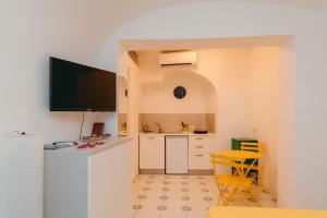 a kitchen with a counter and a table and chairs at Casetta Puntino in Atrani