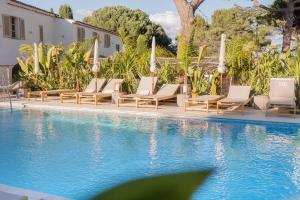a pool with chaise lounge chairs and a resort at Auberge TAO in Biot