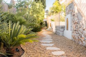a stone path in a garden next to a building at Auberge TAO in Biot