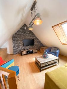 a living room with a tv on a brick wall at Appartement charmant à Sarzeau avec vue sur la mer, 55 m² in Sarzeau +16 photos
