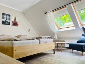 a bedroom with two beds and a blue chair at Wöllbacher Tor in Wetzlar +14 photos