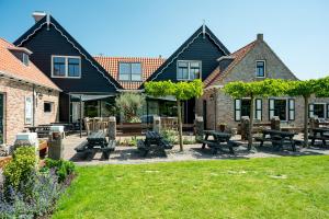 a group of buildings with picnic tables in the grass at Vakantiepark de Meerpaal in Zoutelande
