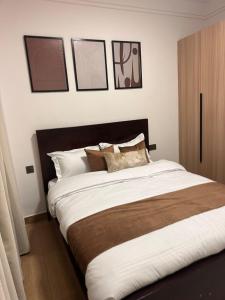 a bedroom with a large bed with four pictures on the wall at Rama Stays in Nairobi +21 photos