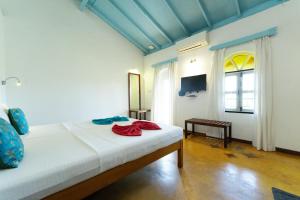 a bedroom with a bed and a television in it at Cavala The Seaside Resort, Baga in Baga +10 photos