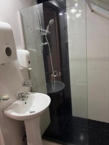 a bathroom with a sink and a glass shower at Yvette B&B in Garni +5 photos