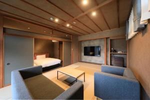 a room with a bed and a couch and a tv at 西伊豆 巡り in Ukusu