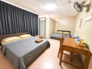 a bedroom with two beds and a table and a desk at HM SweetRest HOTEL in Changlun