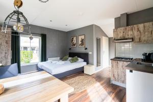 a kitchen and a bedroom with a bed in a room at Vakantiepark de Meerpaal in Zoutelande
