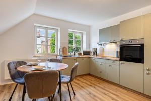 a kitchen with a wooden table and chairs and a dining room at Zeitlos Wriezen 2 in Wriezen