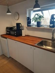 a kitchen counter with a sink and a window at Casa Bonita helt ny lejlighed med eget toilet in Hjørring
