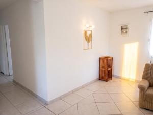 a room with a white wall and a table and a chair at Appartement 3 chambres à Ducos in Ducos