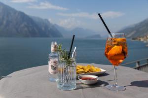 a table with a drink and a plate of food at Piccolo Hotel in Malcesine