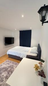 a bedroom with a bed and a tv and a table at Modern Mini Apartment in Malmö