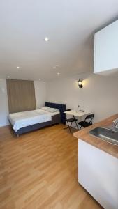 a bedroom with a bed and a kitchen with a sink at Modern Mini Apartment in Malmö