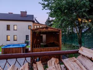 a wooden house with a pool in front of a house at OSNOWA Racławice in Racławice