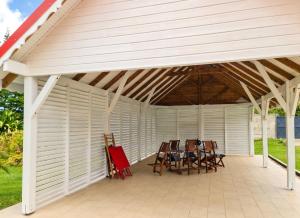 a white pergola with chairs on a patio at Maison accueillante à Anse-Bertrand avec jardin privé 70 m² in Anse-Bertrand