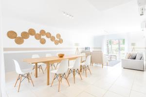 a dining room with a wooden table and white chairs at Laguna - Vilamoura in Vilamoura