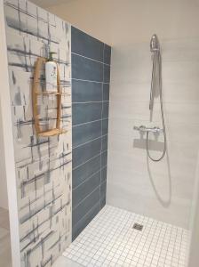 a bathroom with a shower with blue and white tiles at Escale et bien-être in Pornic +62 photos
