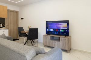 a living room with a couch and a flat screen tv at Beautiful Apartment in Larisa