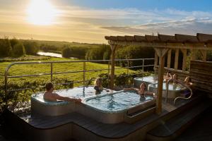 a group of people in a hot tub on a deck at The Piggery at Little Pig in Bude