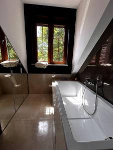 a large bathroom with a tub and a window at Dwór Grabina in Ciechomice +29 photos