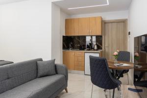 a living room with a couch and a table and a kitchen at Beautiful Apartment in Larisa