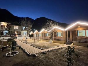 a house with a lit up yard at night at AP cottage and huts in Manāli