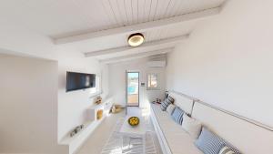 a living room with a couch and a television at Okto in Archangelos