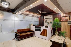 a waiting room with a couch and a table at Hotel Palm Paradise in Noida