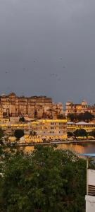 a city with a large building and a body of water at Hotel Lake Star Bistro in Udaipur