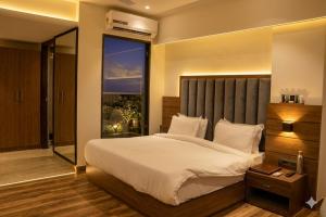 a bedroom with a large bed and a large window at Hotel The Sawai in Jaipur