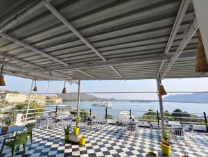 a patio with tables and chairs on a checkered floor at Hotel Lake Star Bistro in Udaipur
