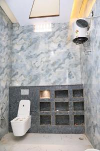 a bathroom with a toilet and a light on the wall at Hotel Ramkesarrai in Ayodhya