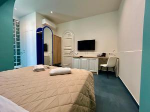 a bedroom with a bed and a desk and a television at La PEPITE in Viareggio