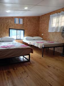 a room with two beds and a window at Gia's Baguio Transient House in Baguio